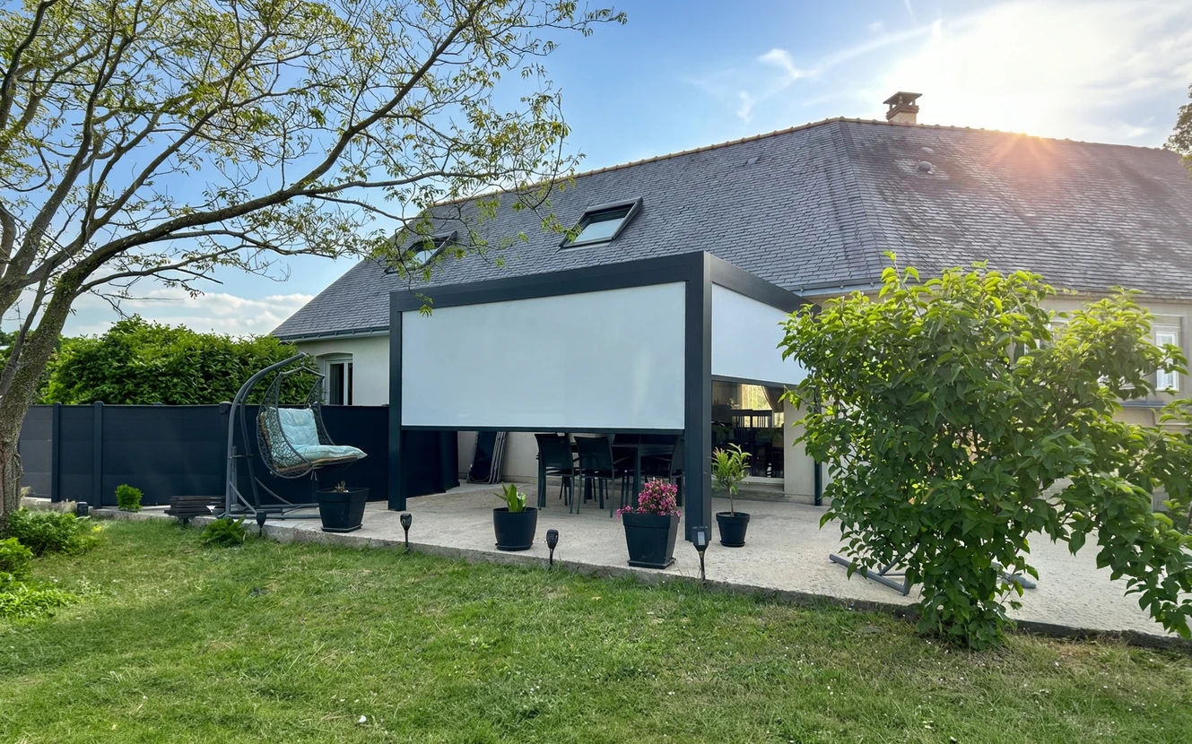 Terrasse couverte par une pergola bioclimatique aluminium anthracite, &eacute;quip&eacute;e d'une toile screen ext&eacute;rieure d&eacute;ploy&eacute;e en fa&ccedil;ade