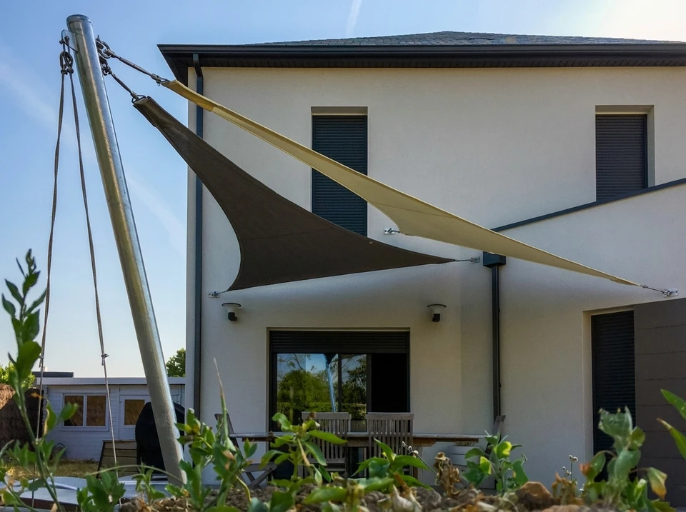 Terrasse extérieure d'appartement avec store banne beige déployé offrant protection solaire